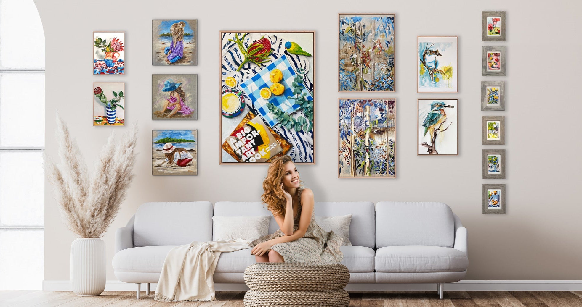 Living room with a woman sitting on a white couch surrounded by colorful abstract paintings on the wall.